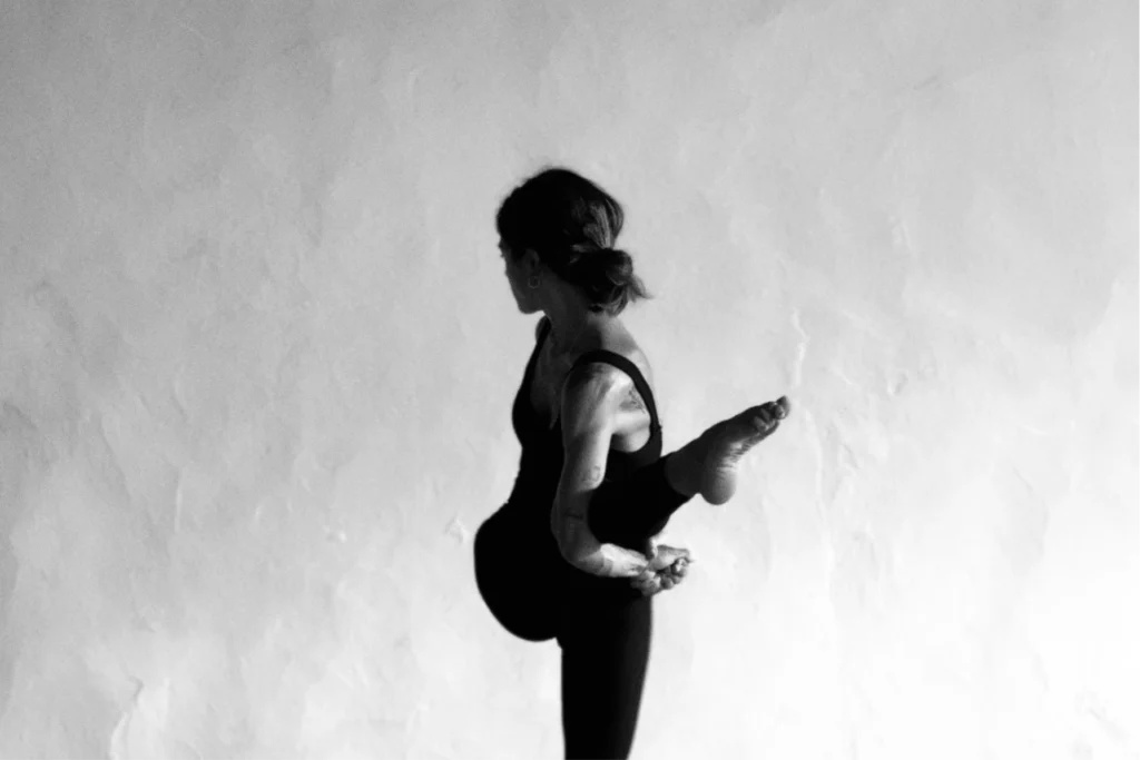 Silueta de practicante en postura de equilibrio lateral, clase de Navakarana Vinyasa en L'Alcudia